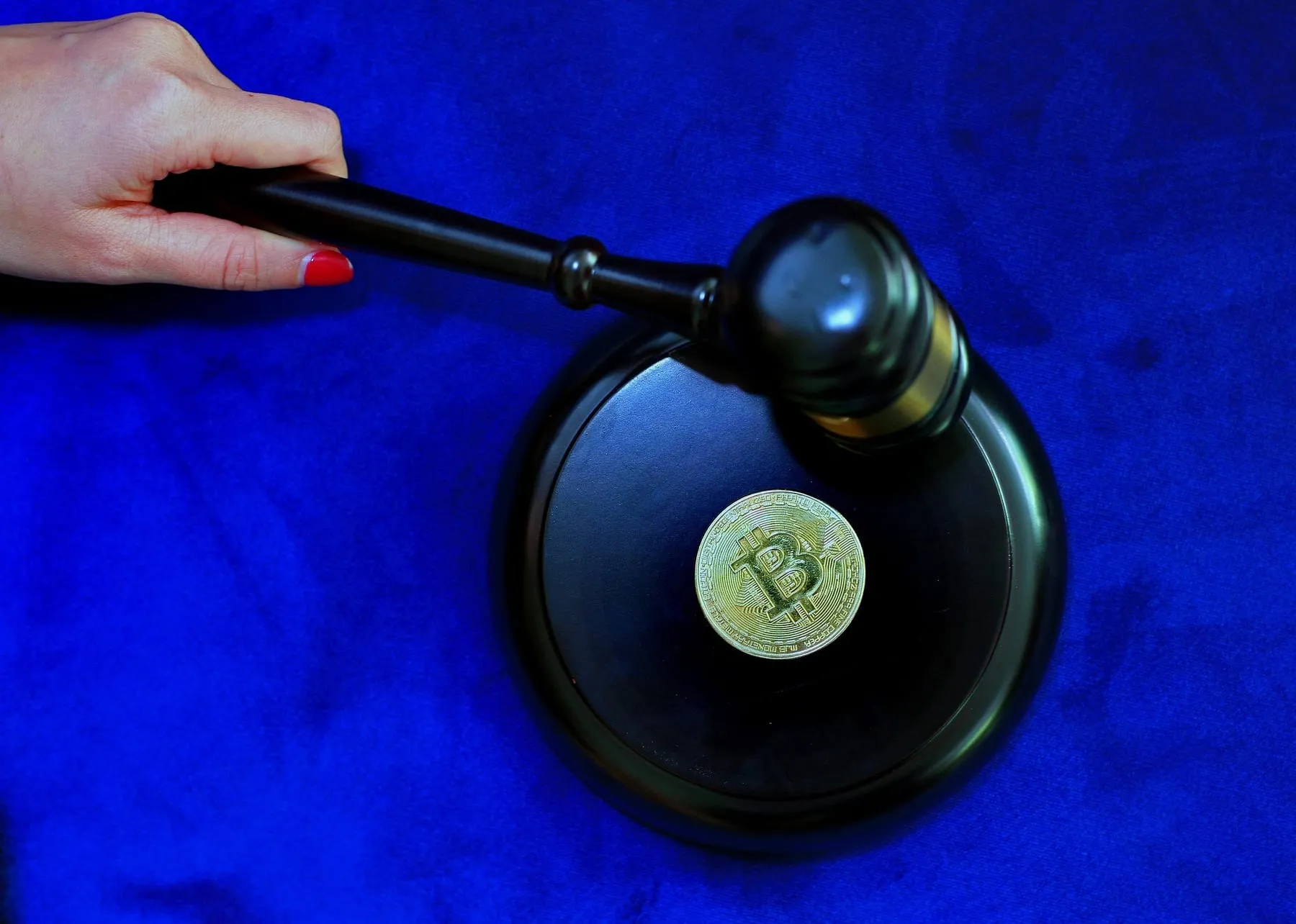 A gavel resting beside a bitcoin token