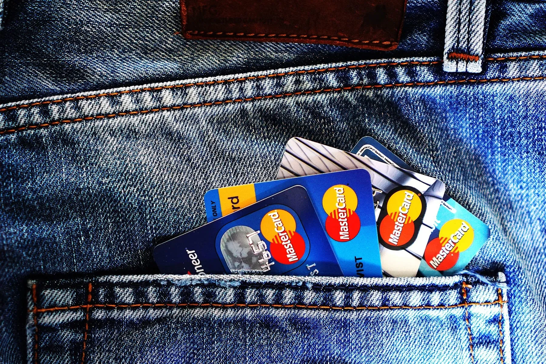 Payment cards tucked into the back pocket of a pair of jeans